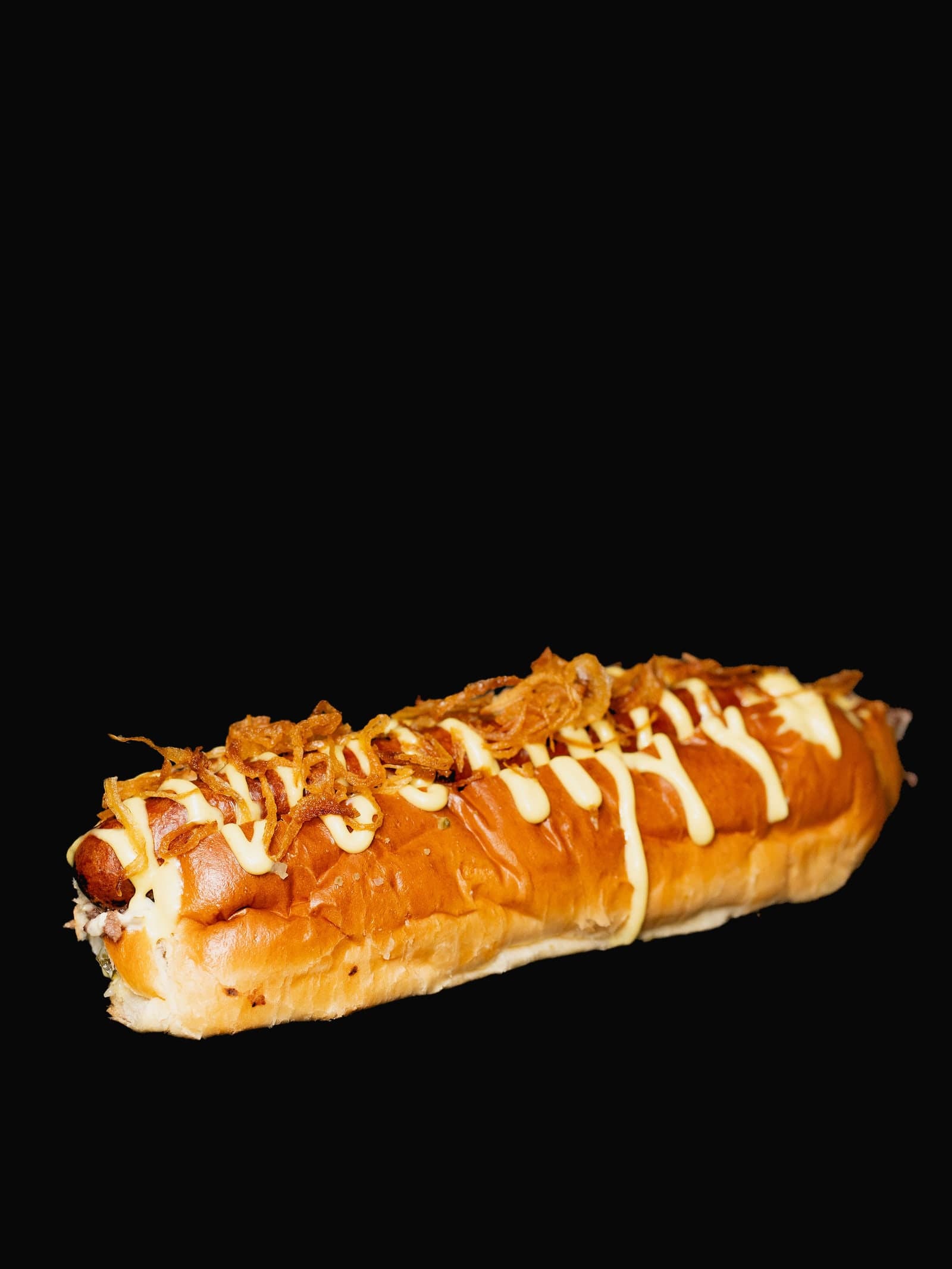 The Bro Dog — A loaded beef dog piled with cheese, caramelised onion and our house sauces. Bun-to-bun comfort.